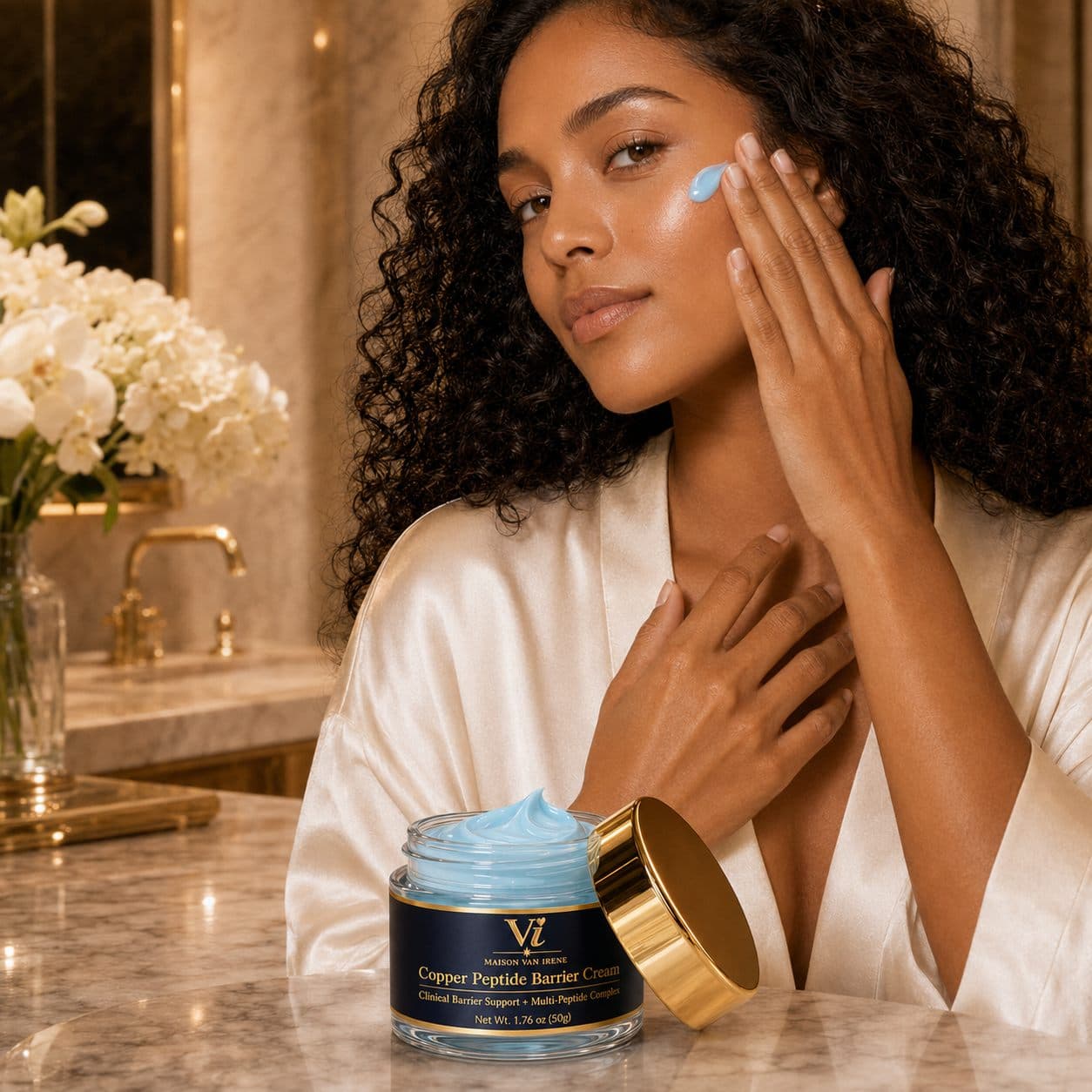 Mujer presionando la Copper Peptide Barrier Cream sobre su mejilla en un baño de mármol de lujo