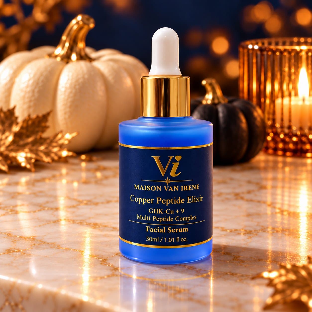 Copper Peptide Elixir bottle with gold dropper collar on a marble counter, candlelight and white pumpkins behind